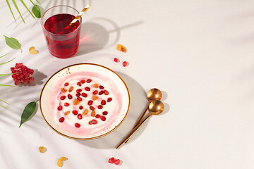Pomegranate yogurt bowl with pomegranate pieces, raisins fresh cream for healthy eating and natural juice. Healthy breakfast with ingredients, kitchen background, Natural nutrition and diet concept