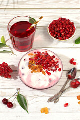Healthy breakfast with ingredients. Pomegranate yogurt with pomegranate berries, raisins and juice on sunny table, detox diet and natural nutrition concept, Healthy lifestyle advertising, baby food.