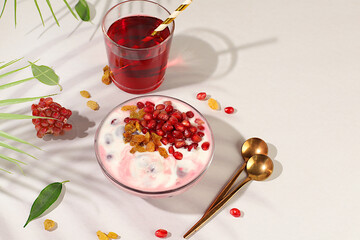 Healthy breakfast with ingredients. Pomegranate yogurt with pomegranate berries, raisins and juice on sunny table, detox diet and natural nutrition concept, Healthy lifestyle advertising, baby food.