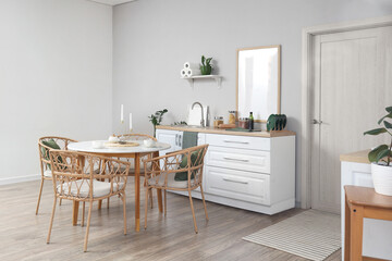 Interior of stylish kitchen with dining table, counters and white door