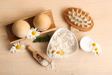 Obraz na płótnie Canvas Composition with bowl of sea salt, chamomile flowers and massage balls on wooden background, closeup