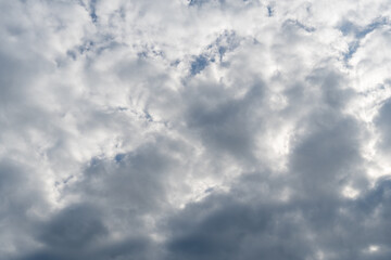Cloudy sky with gray and white formations creating a dramatic atmosphere during the early afternoon