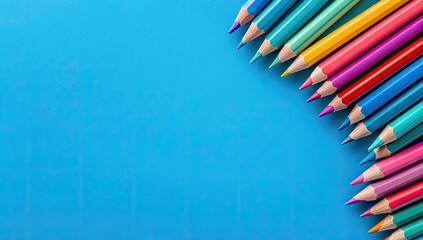 Colorful pencils arranged on blue background, copy space, school supplies, creativity