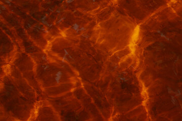 Sunlight creates fiery golden-orange reflections on the rippling water surface, producing a warm and abstract natural pattern.