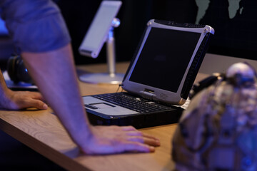 Male soldier working with military laptop on table in office at night, closeup