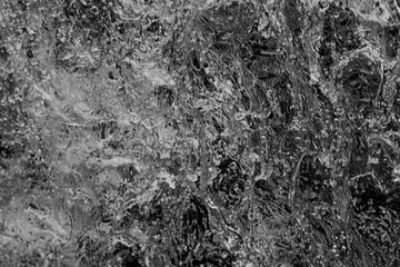 Close-up view of water cascading over moss-covered rocks, highlighting textures, movement, and natural details.