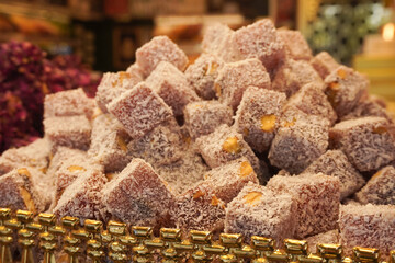 Mouthwatering Turkish delight, piled high with nutty goodness, coated in powdered sugar, vibrant dessert display, traditional confectionery, exotic sweet treat, bakery showcase, colorful candy stack
