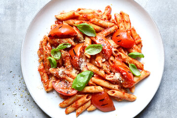 Pasta penne with grilled tomatoes. Top view with copy space.