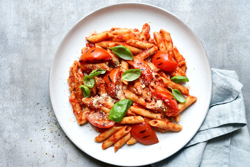Pasta penne with grilled tomatoes. Top view with copy space.