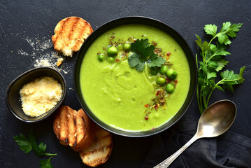 Green pea soup with parmesan and croutons . Top vie with copy space.