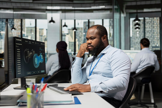 Sustainability specialist in office evaluates environmental impact of wind turbine, upgrading components. Researcher reviews turbine performance data to find ways to save energy and lower costs - Powered by Adobe