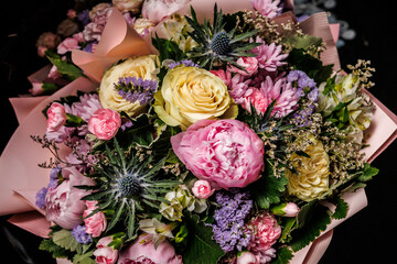 Elegant bouquet of fresh flowers with pink peonies, yellow roses, chrysanthemums and seasonal greenery, perfect decoration for wedding, celebration or romantic gift