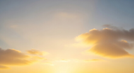 Golden hour sky with soft, yellow cloudscape creating a peaceful and serene atmosphere, ideal for tranquil or nature-themed designs