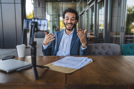 Businessman streaming live video on social media from cafe