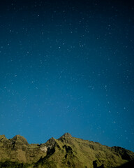 This photograph beautifully captures the majesty of a mountain peak under a clear, starlit sky. 