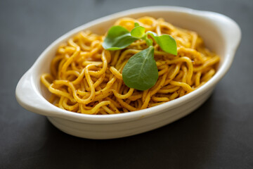 Close-Up of Noodle Salad on an Oval Plate Against a Black Background