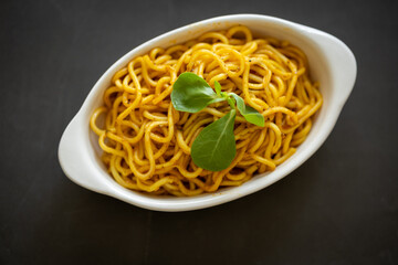 Close-Up of Noodle Salad on an Oval Plate Against a Black Background