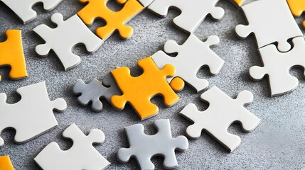 Obraz premium Grey and Yellow Puzzle Pieces Scattered on Gray Surface Close Up