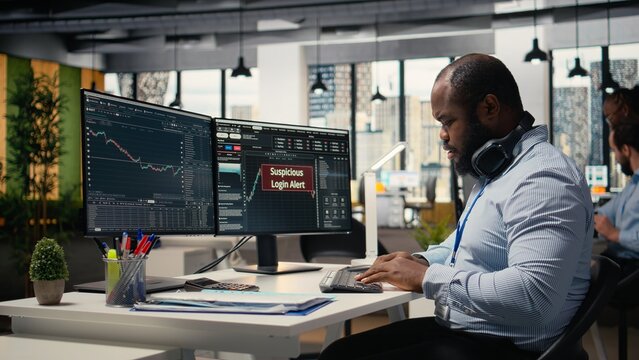 Trader in office spots suspicious login attempt warning on trading platform dashboard, working to fix error. Stockbroker seeing security alert notification of unauthorized login activity