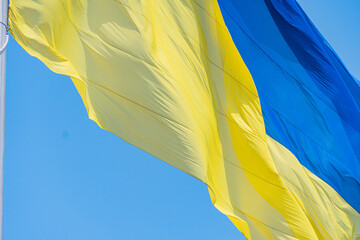 Image of Ukraine flag waving against a clear sky during daytime