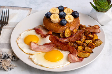 fried eggs with pancakes and bacon