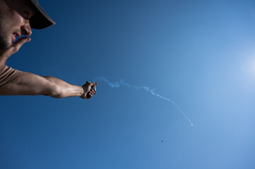 A man fires a flare gun with emergency fire. 