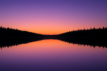 Obraz premium Serene Sunset Reflection on a Still Lake.