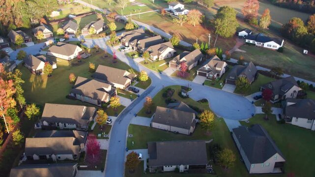 Aerial View of Urban Residential Houses in Suburban Area of South Carolina, United State Autumn Fall Foliage. Colorful Tree Leaves and Homes in Rays of Morning Sun. Residential Houses in Small City.