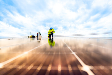A solar energy engineer coordinates a project on the phone while on a rooftop solar installation. A...