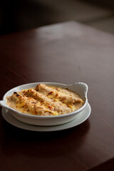 Meat Cannelloni au Gratin with Golden Crust on Wooden Table