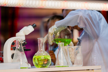 A female scientist teaching a young boy about science in a modern lab. Inspiring the next generation through STEM education, scientific curiosity, and hands on experiments in chemistry and biology.
