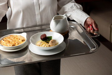 Waiter Carrying Traditional Entrées: Cannelloni and Escudella Soup