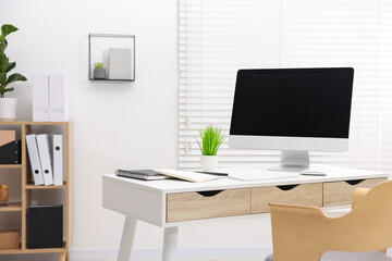 Stylish workplace with modern computer and stationery on white table in office