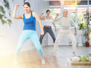 Fototapeta premium Sporty women learning aerobic dances in wellness center