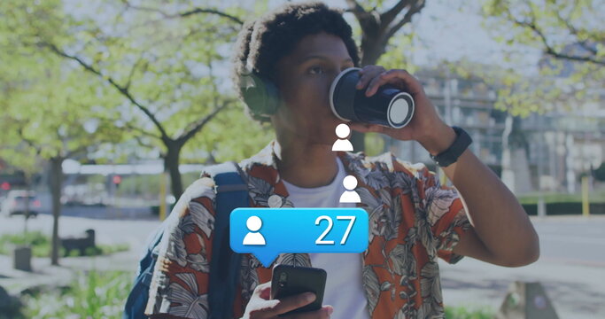 Sipping coffee man in floral shirt and headphones checking phone at park with social media icons - Powered by Adobe