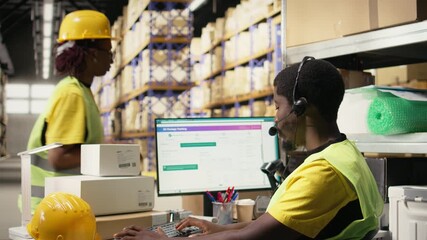 Customer support employee assisting clients in an industrial logistics hub, handling order mix up on e-commerce help line service. Black man resolving issues related to delivery delays. Camera A.