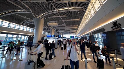 Airport passengers standing in line with luggage, preparing for check in and security control in a modern airport terminal, highlighting the hustle and bustle of air travel