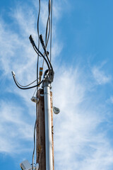 Power utility temporary power drop weatherhead, masthead, to provide electricity to a new build construction site on a sunny blue sky day
