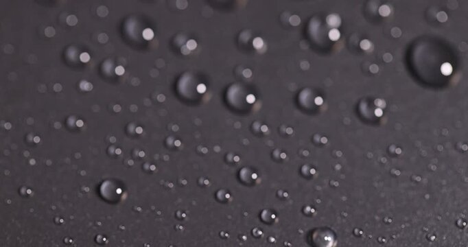 plastic surface covered with water drops, details of the wet part of an object made of black plastic