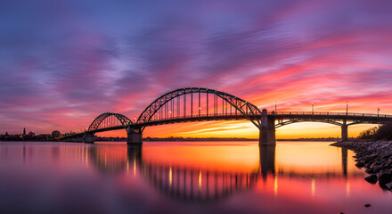 Obraz premium Spectacular sunset over the bridge with vibrant colors reflecting on the water