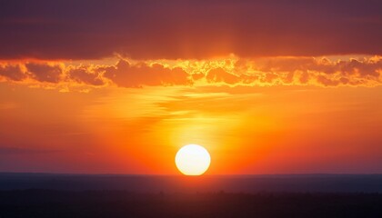 Obraz premium a beautiful sunset with a large sun in the sky