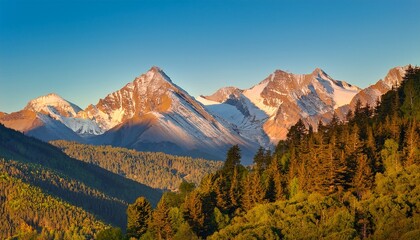 golden hour mountain range with snow capped peaks and lush green trees under clear blue sky