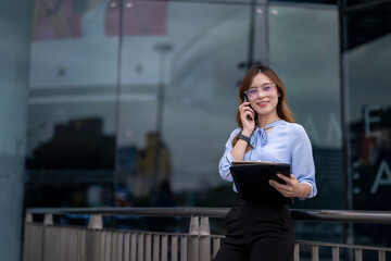 woman is talking on her cell phone while holding a clipboard