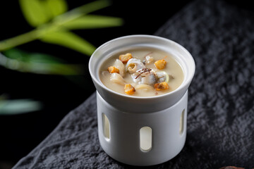 A ceramic cup holds a delicious soup with various ingredients, showcasing a savory and appetizing dish.