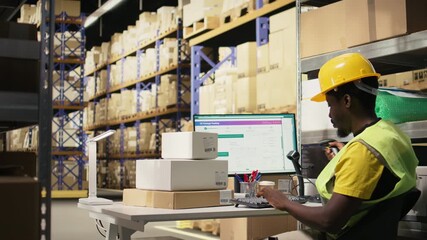 African American male employee scanning packages in a large warehouse, registering airway bills shipment details within industrial depot records. Using scanner for order fulfillment. Camera A.