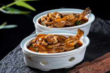 A close-up of two bowls of braised fish with mushrooms in a rich, aromatic soup, showcasing the appetizing dish.