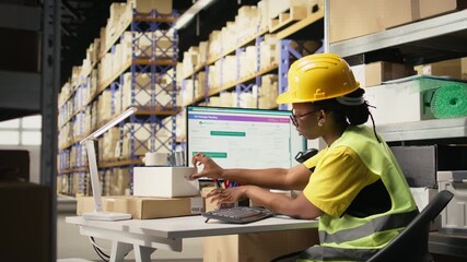 Black worker applying and scanning barcodes awb tags on cargo boxes, registering the merchandise and shipment details before distribution. Using scanner on tracking numbers in depot. Camera A.