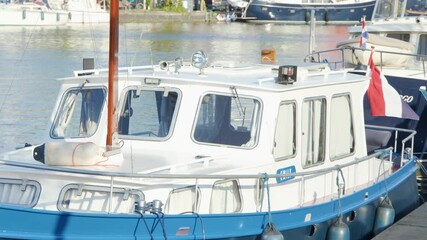 Dutch Canal Boat with Flag Moves Along Haarlem Waterfront - Powered by Adobe