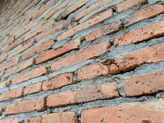 Angled View of a Rustic Red Brick Wall with Coarse Mortar
