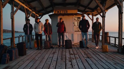 Tourists are waiting on a wooden pier with luggage at sunset, ready for their journey, creating a nostalgic and exciting atmosphere of travel and adventure